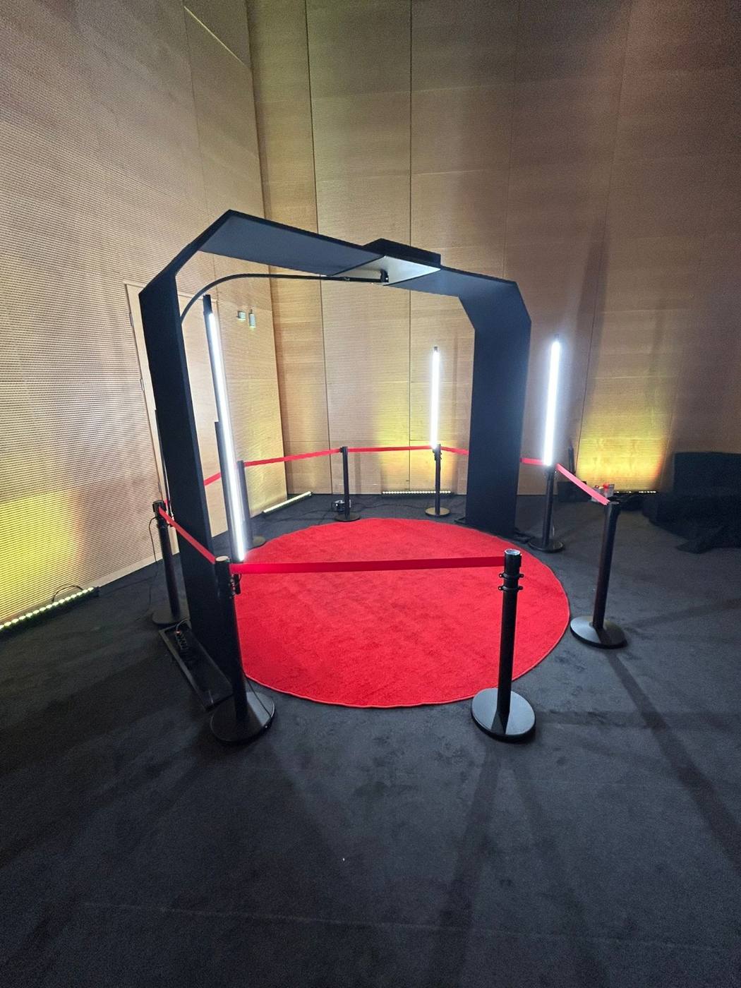 Fotobudka 360° z łukiem na czerwonym dywanie, ze słupkami z liną
